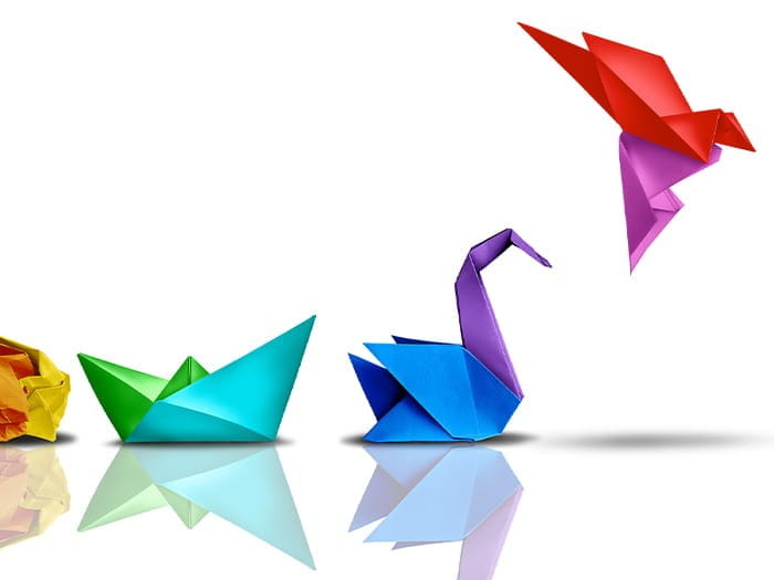 paper origami shapes transforming into a flying bird, starting with a scrunched ball, boat, swan then a flying bird wings different colours