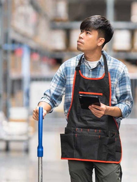 warehouse employee young asian man wearing an apron pushing a trolley trade exports boxes