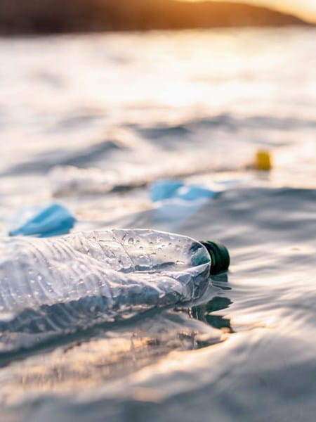 Image of plastic waste (bottles) floating in the ocean.